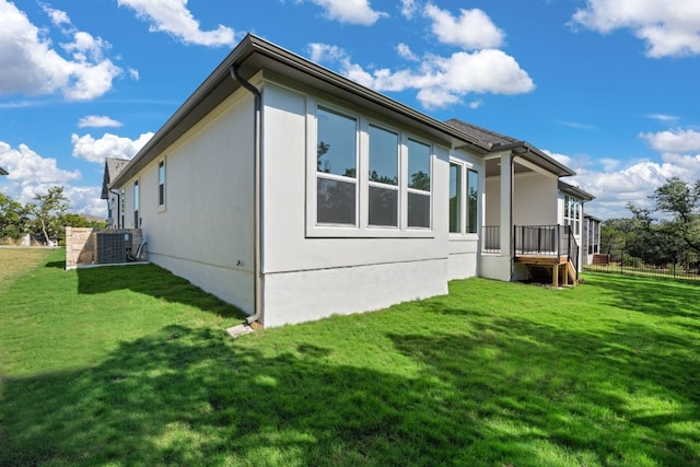 view of home's exterior featuring central AC unit and a lawn