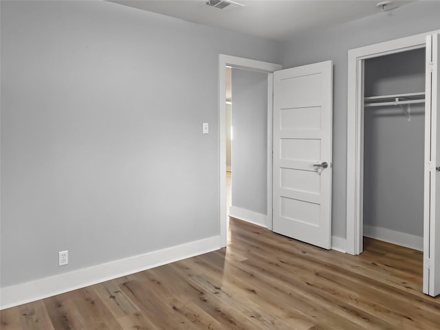 unfurnished bedroom with hardwood / wood-style floors and a closet