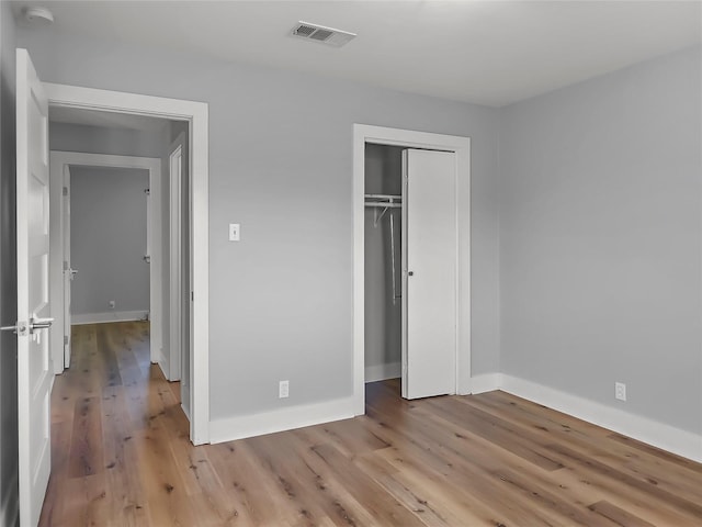 unfurnished bedroom featuring light hardwood / wood-style flooring and a closet