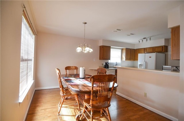 dining area featuring a chandelier, light wood-type flooring, and a wealth of natural light