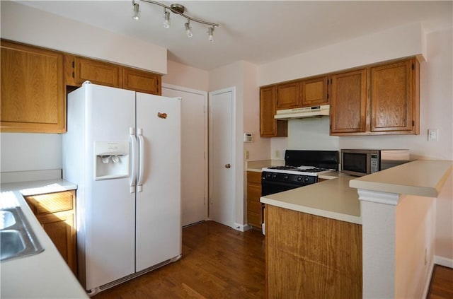 kitchen with kitchen peninsula, dark hardwood / wood-style floors, and white appliances