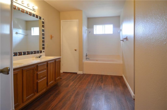 bathroom featuring hardwood / wood-style flooring, vanity, and tiled shower / bath combo