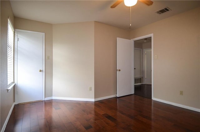 unfurnished bedroom with ceiling fan and dark wood-type flooring