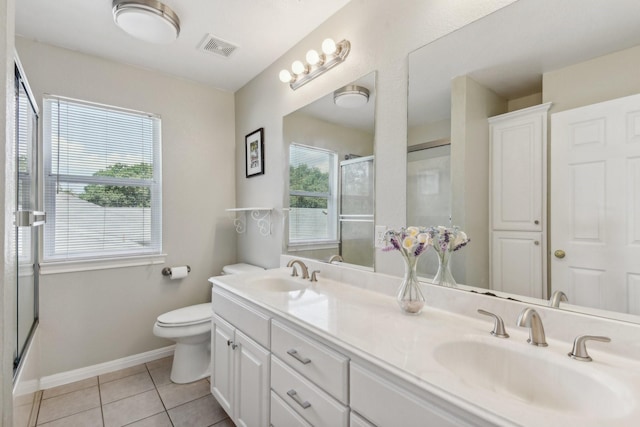 bathroom featuring tile patterned floors, vanity, an enclosed shower, and toilet