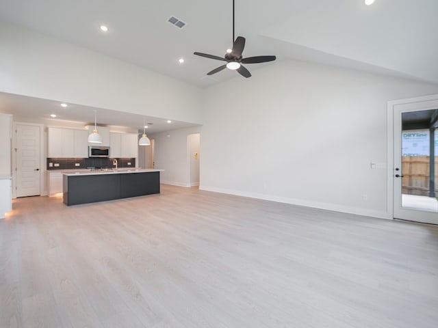 unfurnished living room with high vaulted ceiling, ceiling fan, and light hardwood / wood-style floors