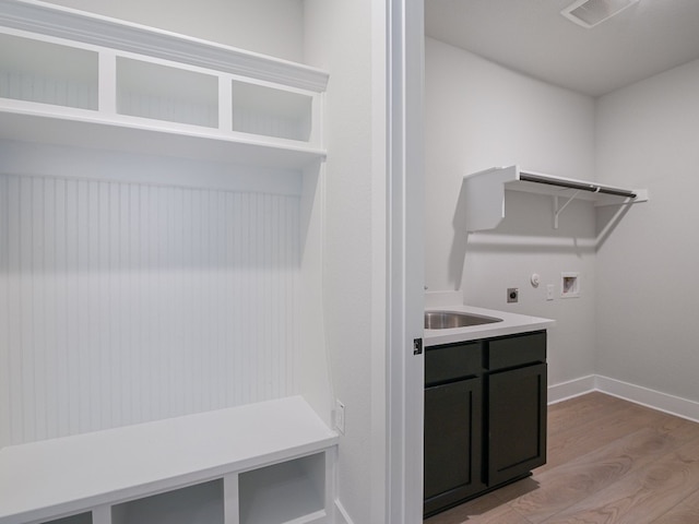 laundry room featuring washer hookup, electric dryer hookup, sink, and light hardwood / wood-style floors