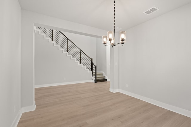 unfurnished dining area with light hardwood / wood-style floors and a chandelier