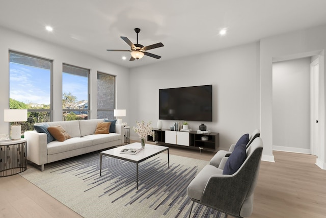 living room featuring light hardwood / wood-style flooring and ceiling fan