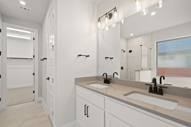 bathroom featuring a shower with shower door, tile patterned floors, and vanity