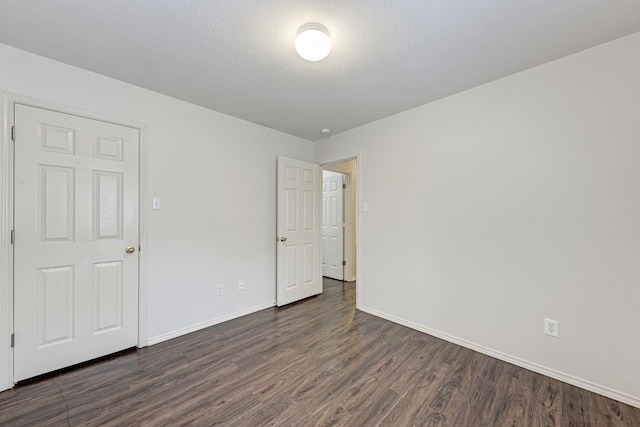 unfurnished room featuring dark hardwood / wood-style flooring and a textured ceiling