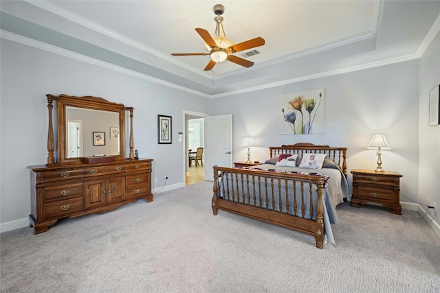 bedroom with a tray ceiling, ceiling fan, ornamental molding, and light colored carpet