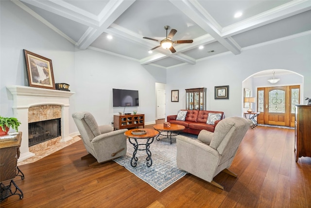 living room featuring coffered ceiling, a fireplace, beamed ceiling, and dark hardwood / wood-style floors