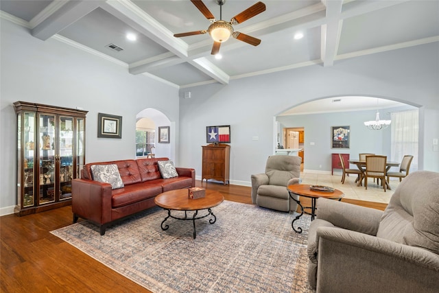 living room featuring hardwood / wood-style floors, ceiling fan with notable chandelier, beam ceiling, and crown molding