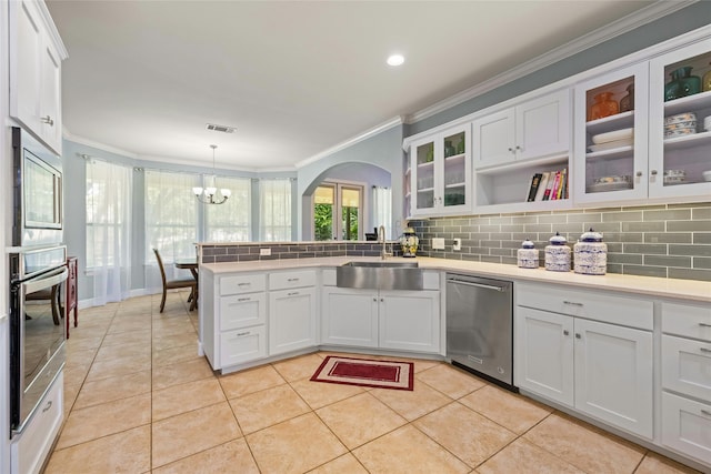 kitchen with sink, stainless steel appliances, white cabinets, decorative light fixtures, and light tile patterned flooring