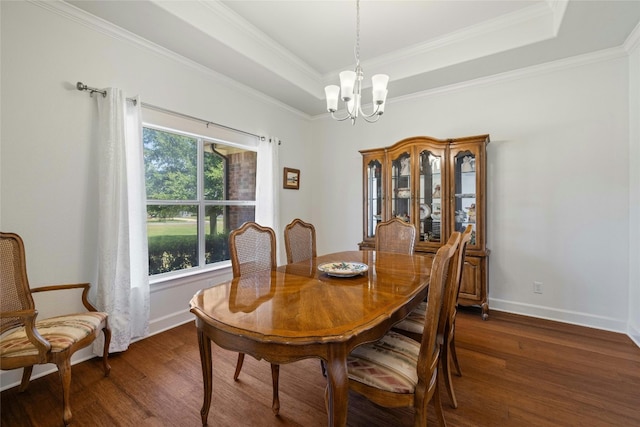 dining space featuring dark hardwood / wood-style floors, an inviting chandelier, a healthy amount of sunlight, and a tray ceiling