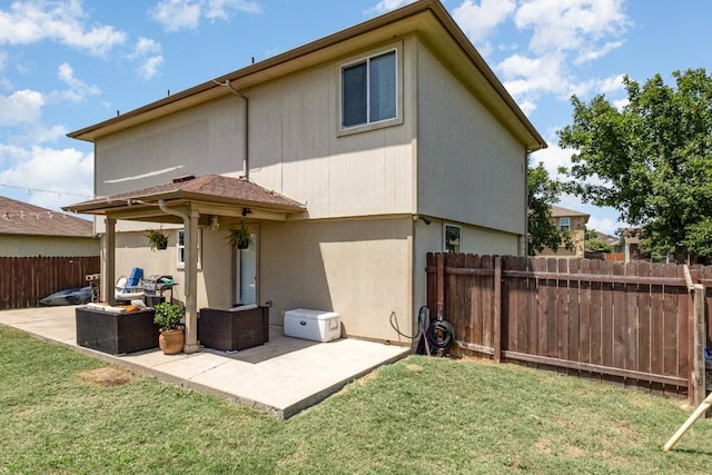 back of house featuring a patio and a lawn