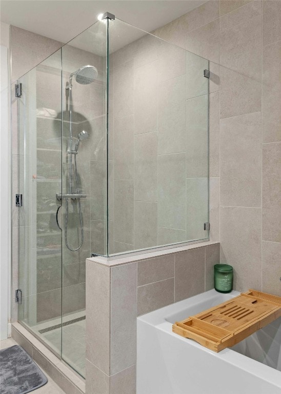 bathroom with tile walls and separate shower and tub