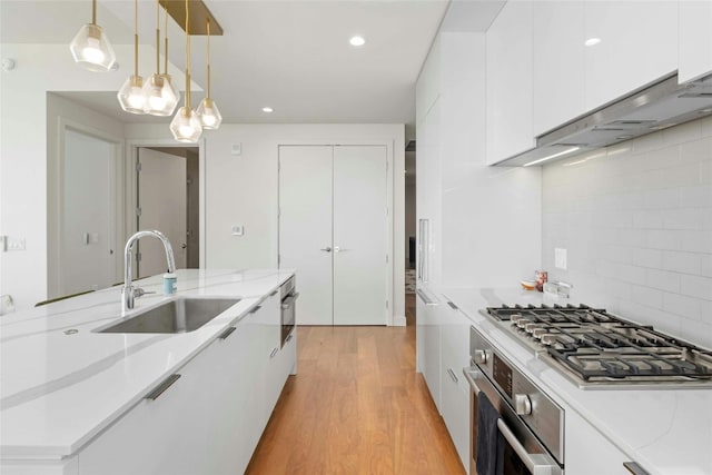 44 E Ave Unit 1507, Austin, TX 78701 - kitchen with a sink, modern cabinets, appliances with stainless steel finishes, white cabinetry, and recessed lighting