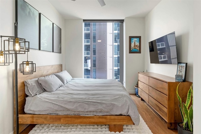 bedroom featuring expansive windows and light wood-type flooring