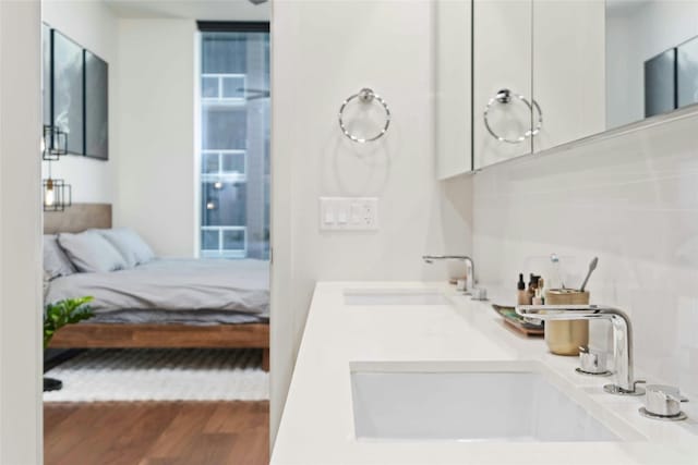 44 E Ave Unit 1507, Austin, TX 78701 - ensuite bathroom featuring wood finished floors and double vanity