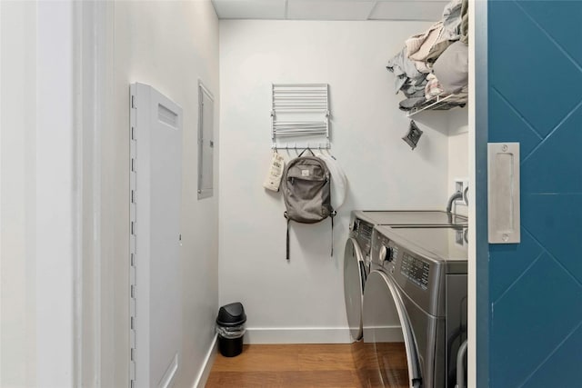 clothes washing area featuring independent washer and dryer, electric panel, and hardwood / wood-style floors