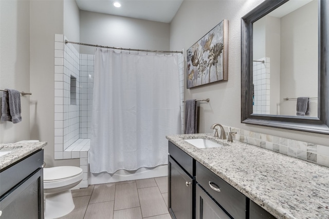 full bathroom featuring shower / bath combo with shower curtain, vanity, tile patterned floors, and toilet