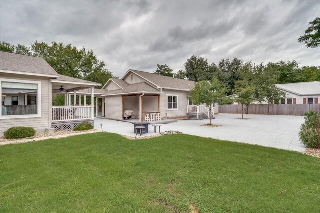 rear view of property featuring a patio and a yard