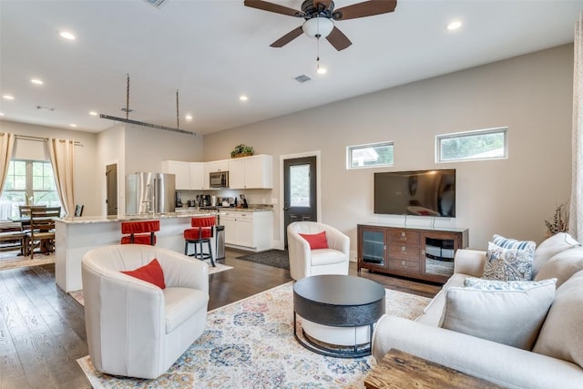 living room featuring dark wood-type flooring and ceiling fan