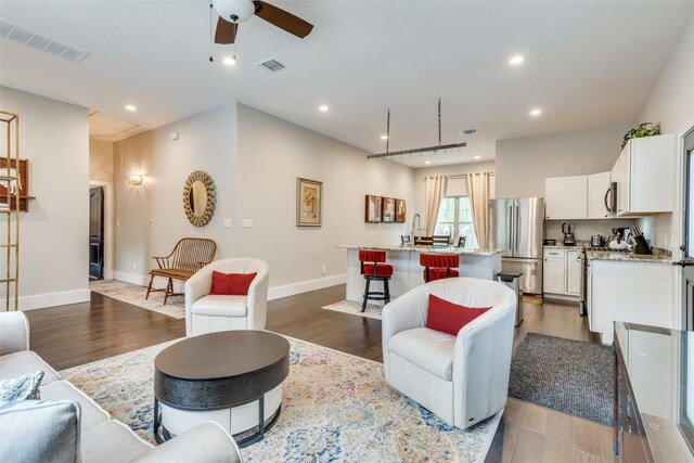 living room featuring wood-type flooring and ceiling fan