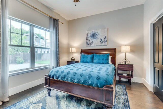 bedroom with dark hardwood / wood-style flooring, multiple windows, and ceiling fan