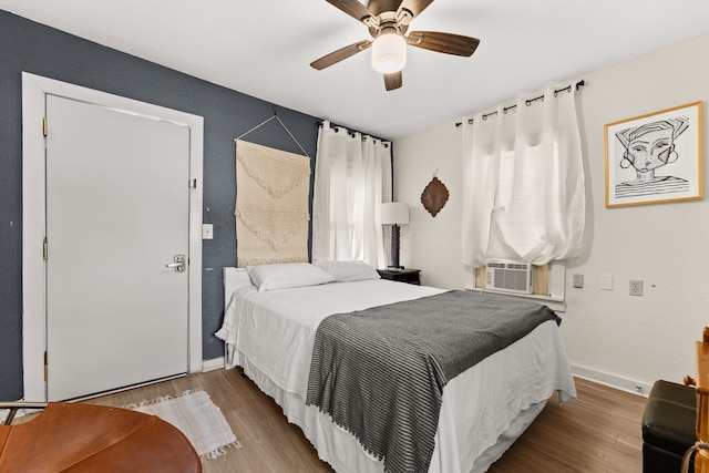 bedroom featuring ceiling fan, light hardwood / wood-style flooring, and multiple windows