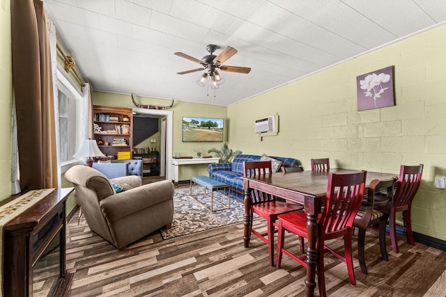 dining space with ceiling fan, wood-type flooring, and a wall mounted air conditioner