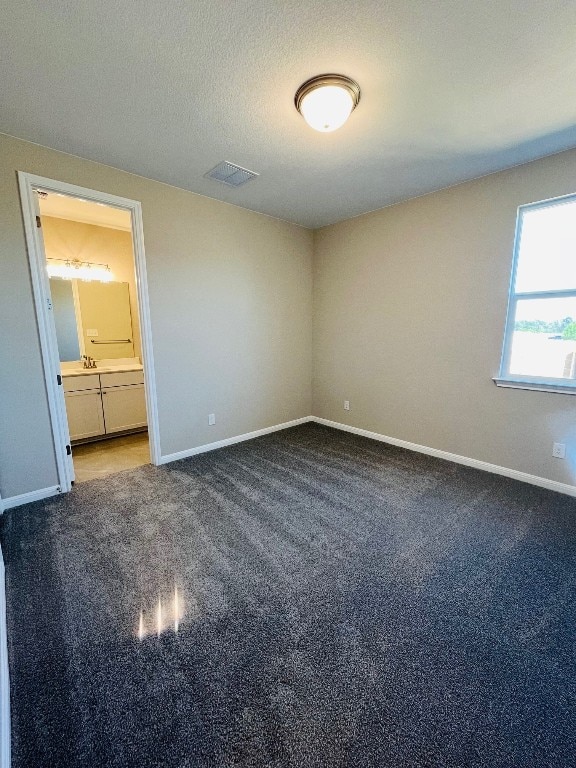 carpeted empty room with a textured ceiling