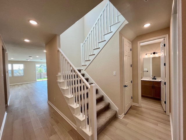 staircase with sink and wood-type flooring