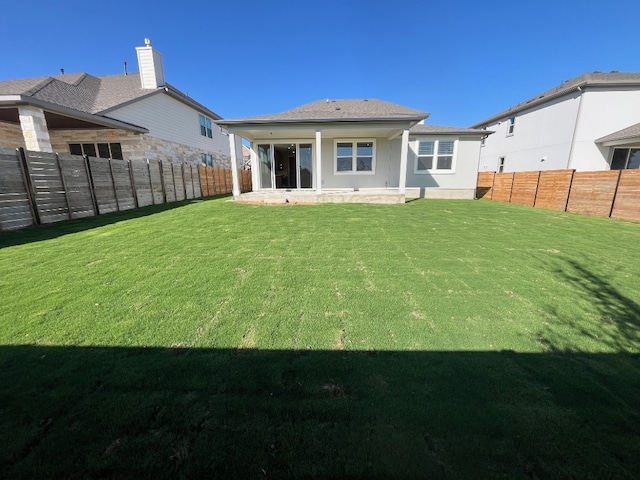 back of house with a lawn and a patio area