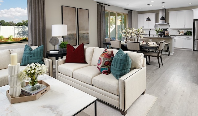 living room with light hardwood / wood-style floors and sink