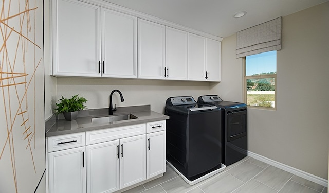 laundry room with cabinets, separate washer and dryer, and sink