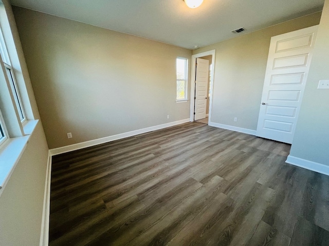 unfurnished bedroom with dark hardwood / wood-style floors and a closet