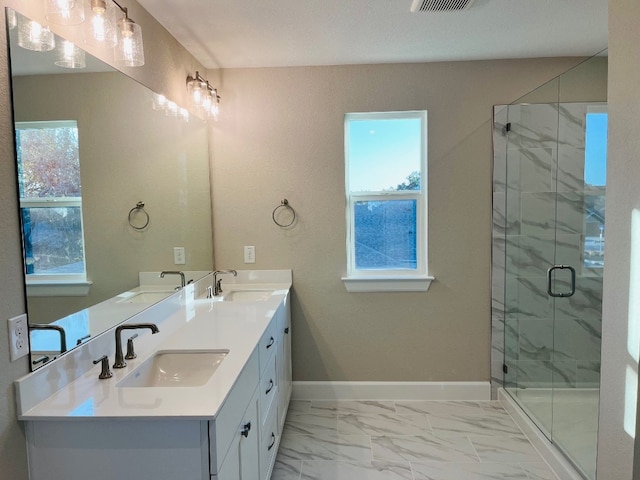 201 Alistair Dr, Georgetown, TX 78633 - bathroom with marble look tile flooring, double vanity, a marble finish shower, and baseboards