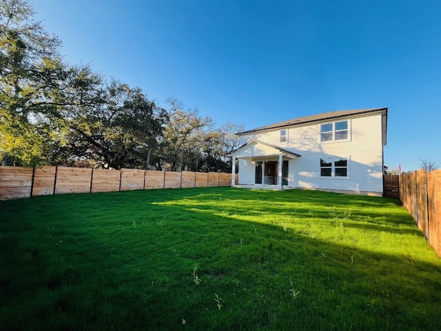 back of house with a lawn and a patio area