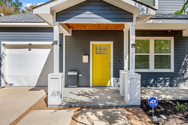 doorway to property with a porch and a garage