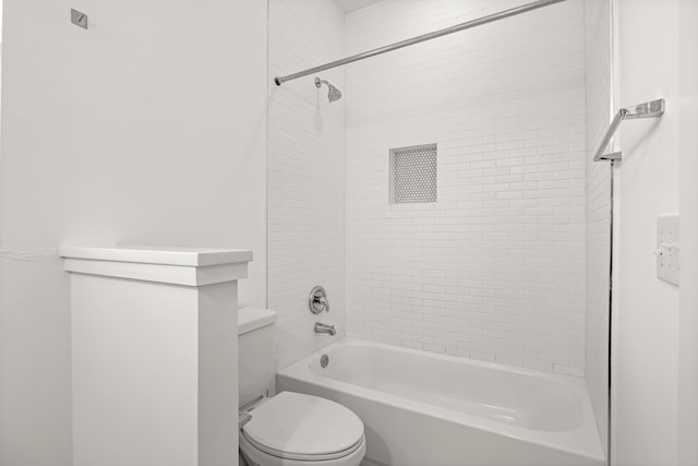 bathroom with toilet and tiled shower / bath