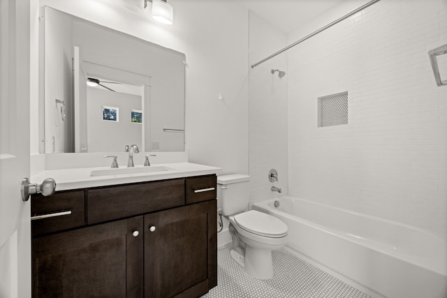 full bathroom featuring tiled shower / bath, tile patterned flooring, ceiling fan, toilet, and vanity