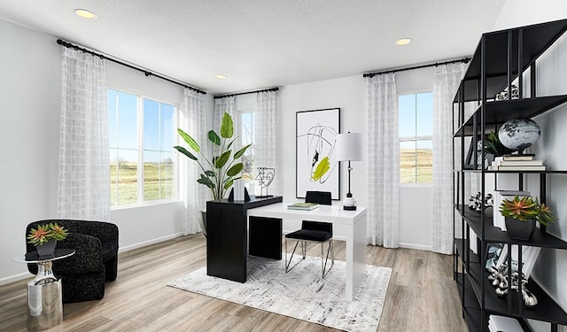 office area with a textured ceiling and light wood-type flooring