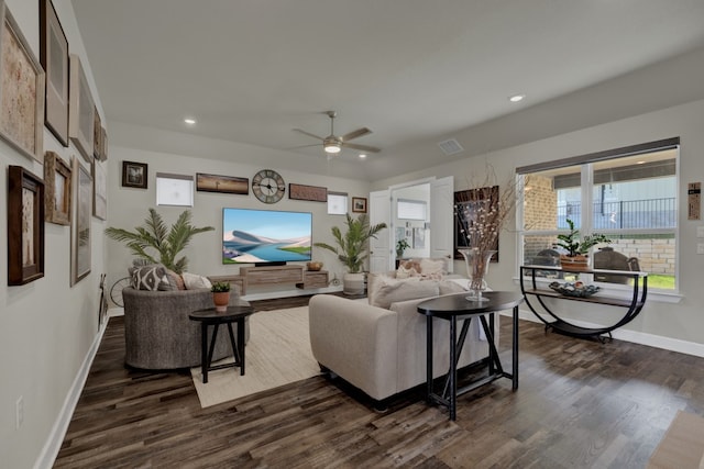 living room featuring dark wood-type flooring and ceiling fan