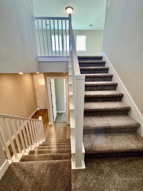524 Raleigh Dr, Georgetown, TX 78633 - stairway with wood finished floors, baseboards, and a towering ceiling