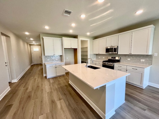 kitchen featuring white cabinets, sink, an island with sink, and appliances with stainless steel finishes