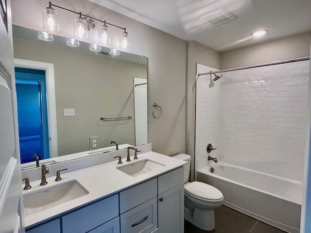 full bathroom featuring vanity, tile patterned floors, tiled shower / bath combo, and toilet