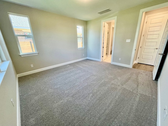 unfurnished bedroom with multiple windows and carpet