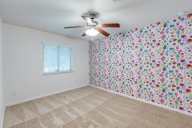 empty room with ceiling fan and light carpet